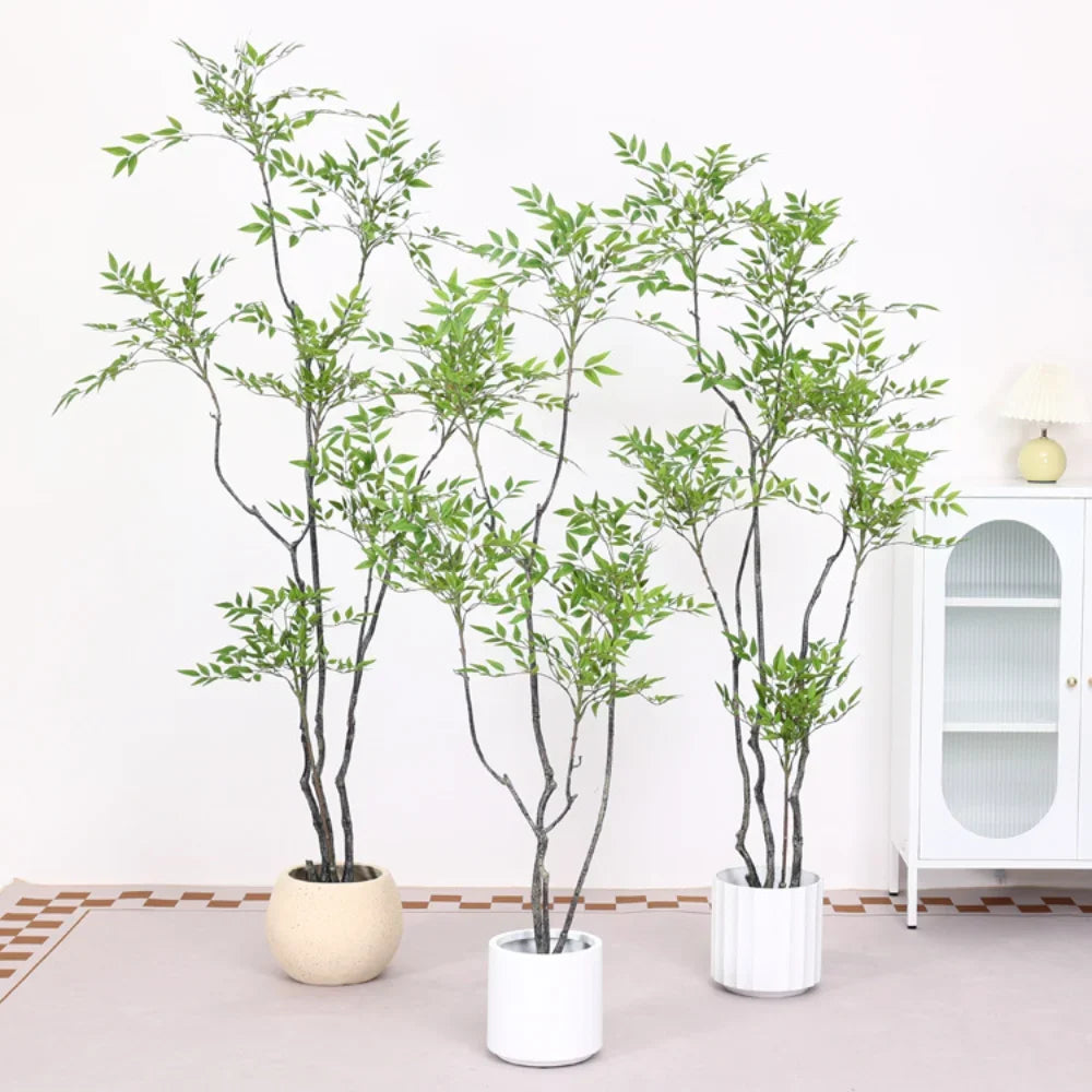 A tall artificial Nandina plant with green foliage in a white pot displayed indoors.