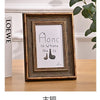 A dark wood photo frame with a gold border displaying the text Home is Where The Is.