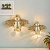 Handgefertigte goldene Bienenwandskulptur, montiert an einer hellblauen Wand.