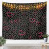 A dark tapestry wall hanging featuring a leopard print pattern with warm string lights outlining pink hearts.