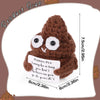 A handmade brown crochet potato doll with large eyes and an inspirational card attached.