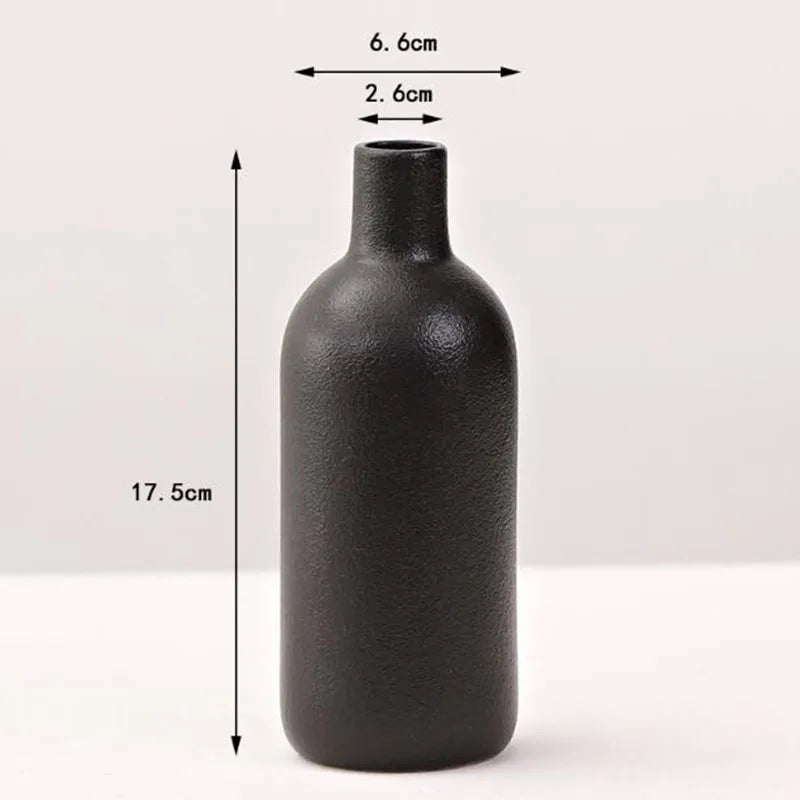 A matte black ceramic vase with a cylindrical body and a narrow neck, shown against a white background.