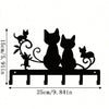 Black silhouette wall decor featuring three cats and decorative swirls on a wooden plank.