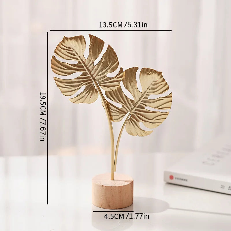 A gold-colored iron ginkgo leaf ornament set with a wooden base, shown against a white background.