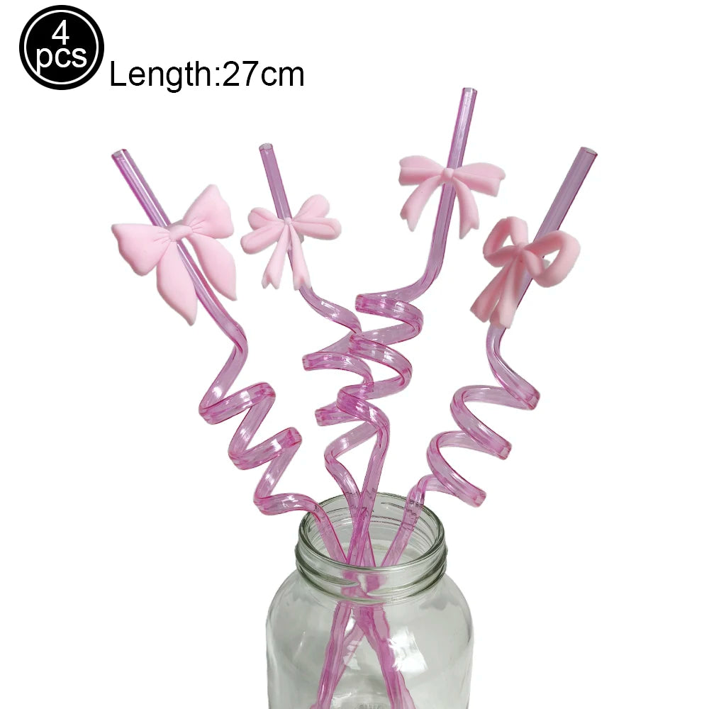 A set of four pink disposable party straws with bow decorations stored in a glass jar.