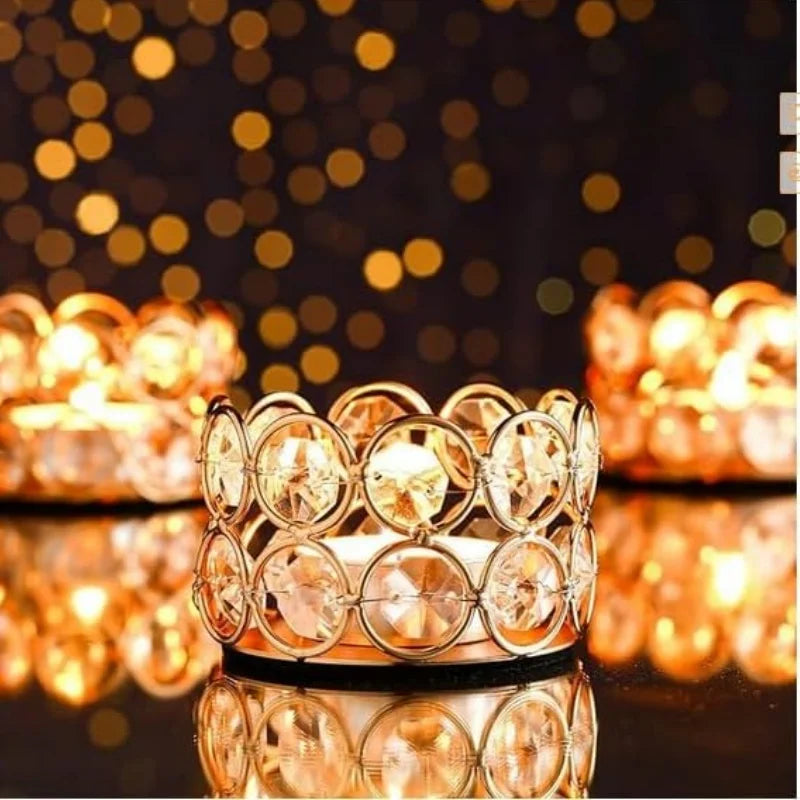 A close-up of a crystal tealight candle holder with a metal base surrounded by glowing candles.