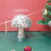 A silver mushroom-shaped disco ball decoration with a faceted dome and pedestal stands on a green surface.