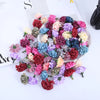 Un plat rempli de mini fleurs d'hydrangea artificielles dans diverses nuances de rose, violet, rouge et bleu.