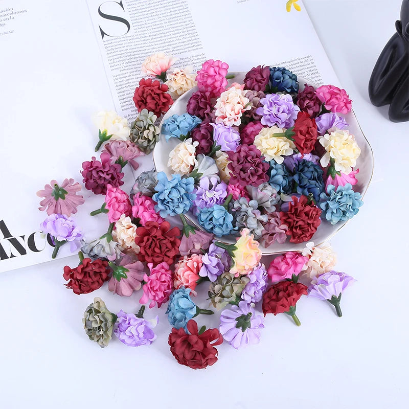 Un plat rempli de mini fleurs d'hydrangea artificielles dans diverses nuances de rose, violet, rouge et bleu.