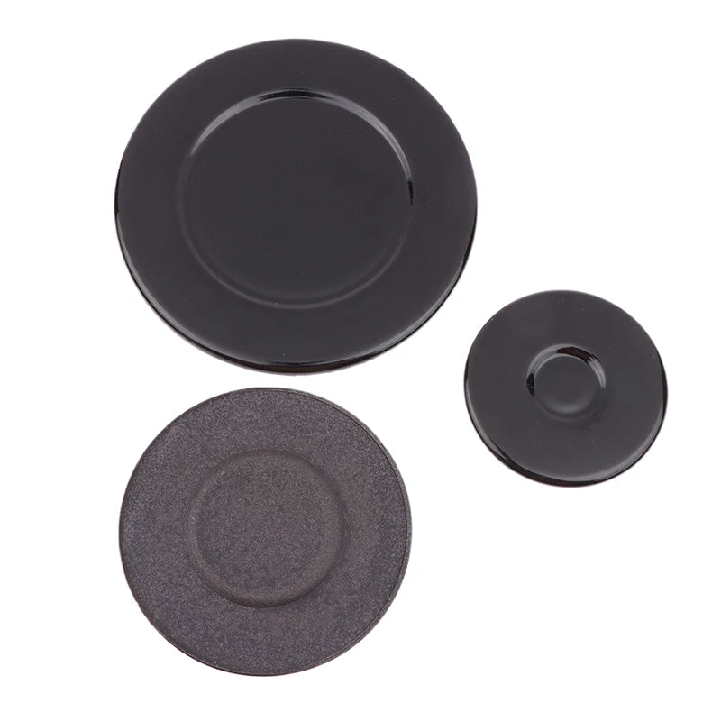 A set of two round, black gas stove burner caps, one glossy and one matte.
