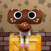 A brown plush toy with large black eyes and small star embellishments is displayed on a yellow wooden box.