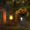A solar grave memorial vase with an LED light sits on a grassy cemetery plot at night.