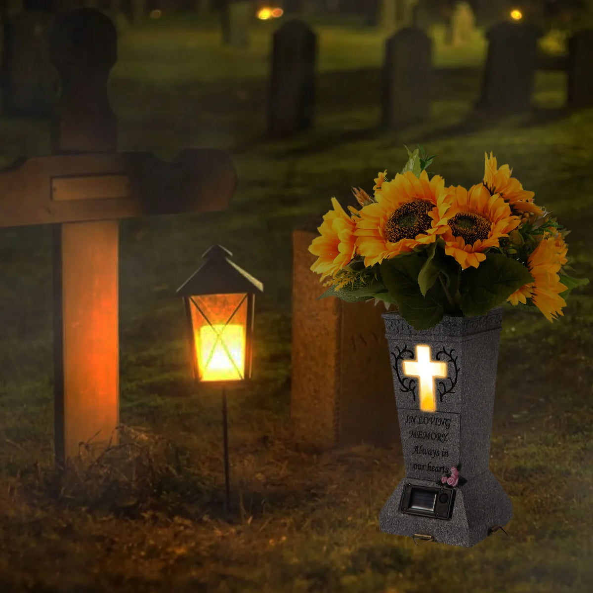 A solar grave memorial vase with an LED light sits on a grassy cemetery plot at night.