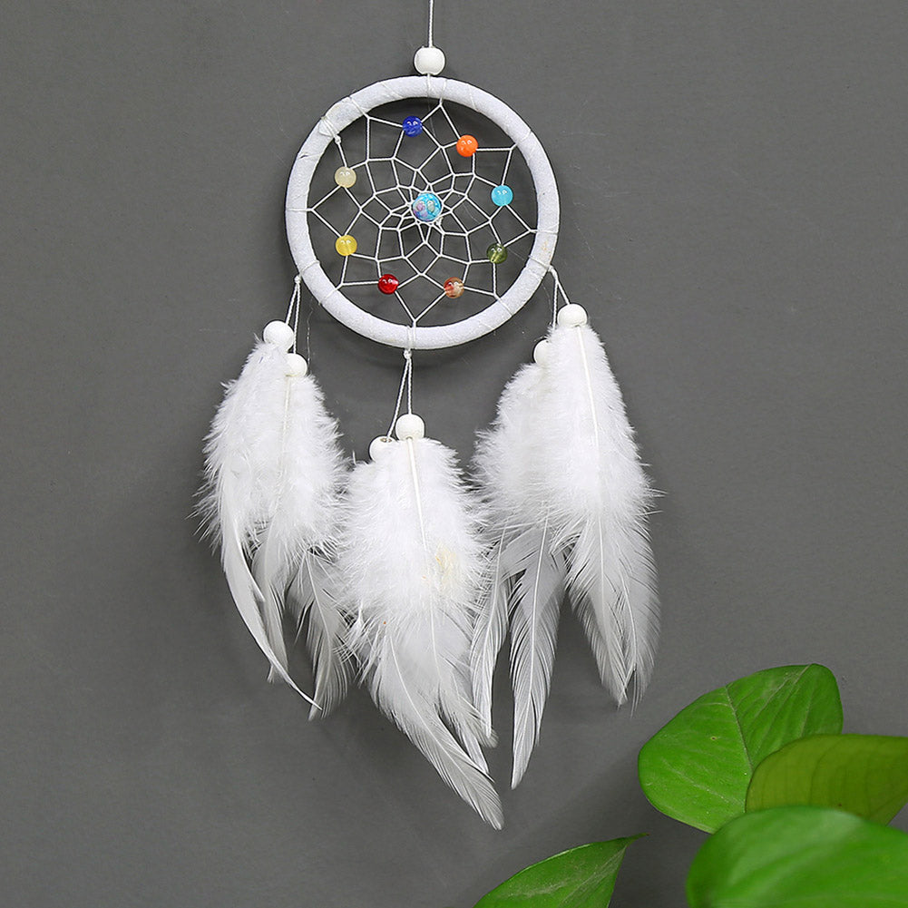 Handmade feather dreamcatcher wall decor with a white circle and colorful beads hanging from it.