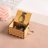 A hand-cranked wooden music box featuring a Totoro design, set in a decorative wooden box.