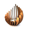 A wooden candle holder decoration made of curved slats, resembling a lotus flower, with a white candle inside.