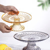 A hand is holding a clear acrylic serving plate for fruit or appetizers above another similar glass plate.