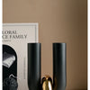A set of matte black U-shaped ceramic tabletop vases displayed on a white surface.