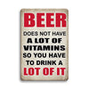 A vintage metal tin sign with red text that reads Beer does not have a lot of vitamins so you have to drink a lot of it