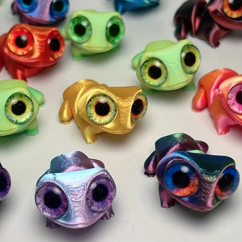 A collection of 3D printed frog car ornaments featuring various colors and color-shifting eyes.