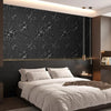 A modern bedroom featuring a bed with white linens and dark floral wallpaper.
