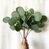 A hand holds a bundle of artificial baby's breath flowers for floral arrangements.