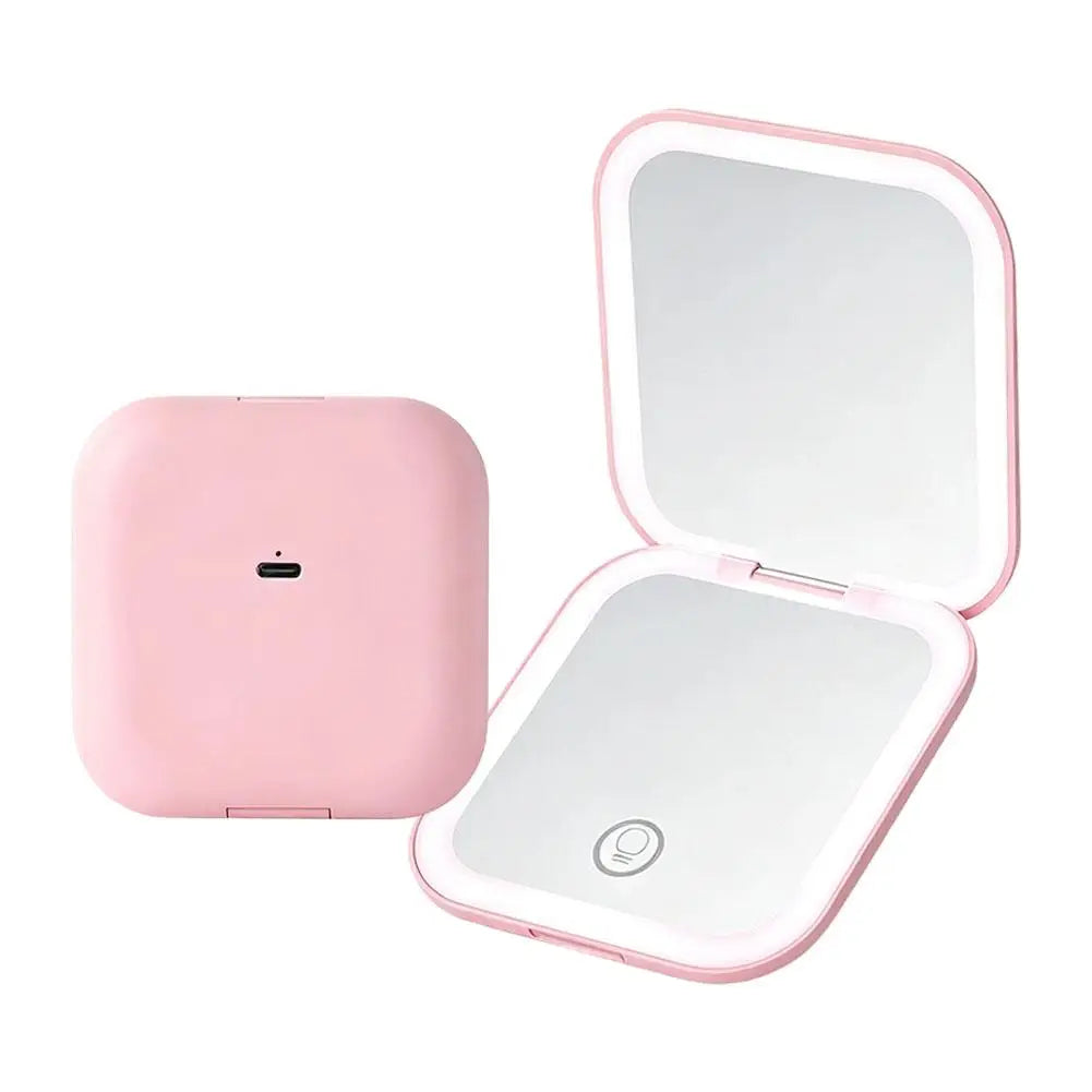 A pink portable folding LED makeup mirror with a reflective surface and a magnifying lens.