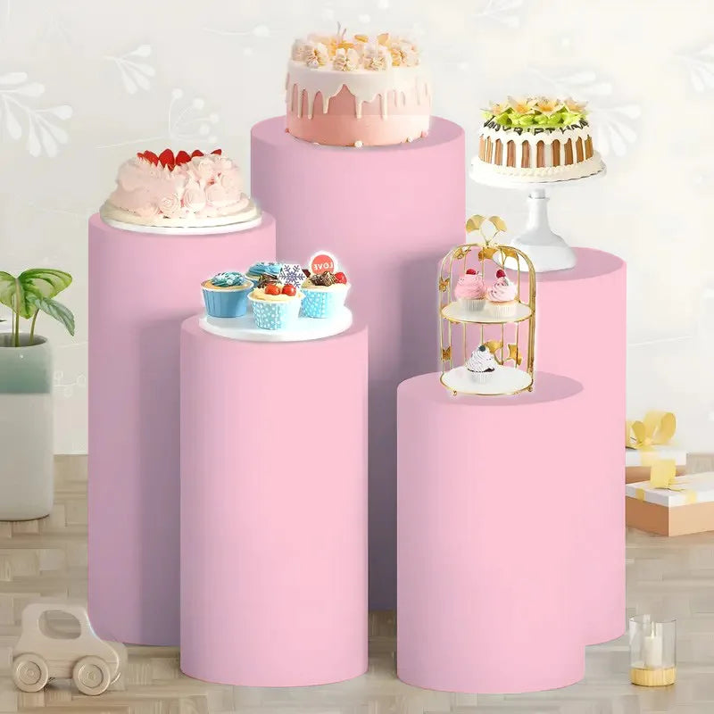 Pink elastic cylinder stands decorated with tiered cakes and treats for party and event display
