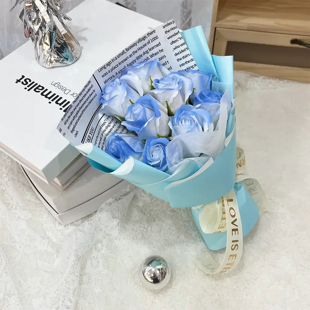 A bouquet of light blue artificial roses wrapped in a teal paper and tied with white ribbon.