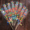 Clear cellophane gift bags filled with colorful candies and party favors on wooden surface