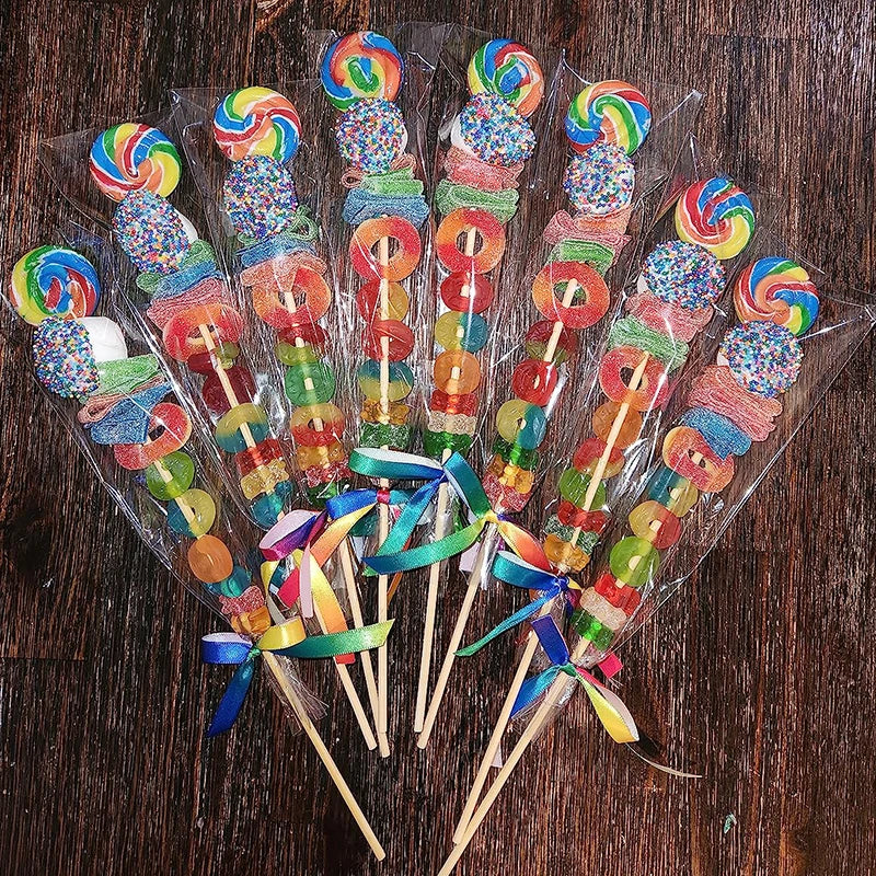 Clear cellophane gift bags filled with colorful candies and party favors on wooden surface