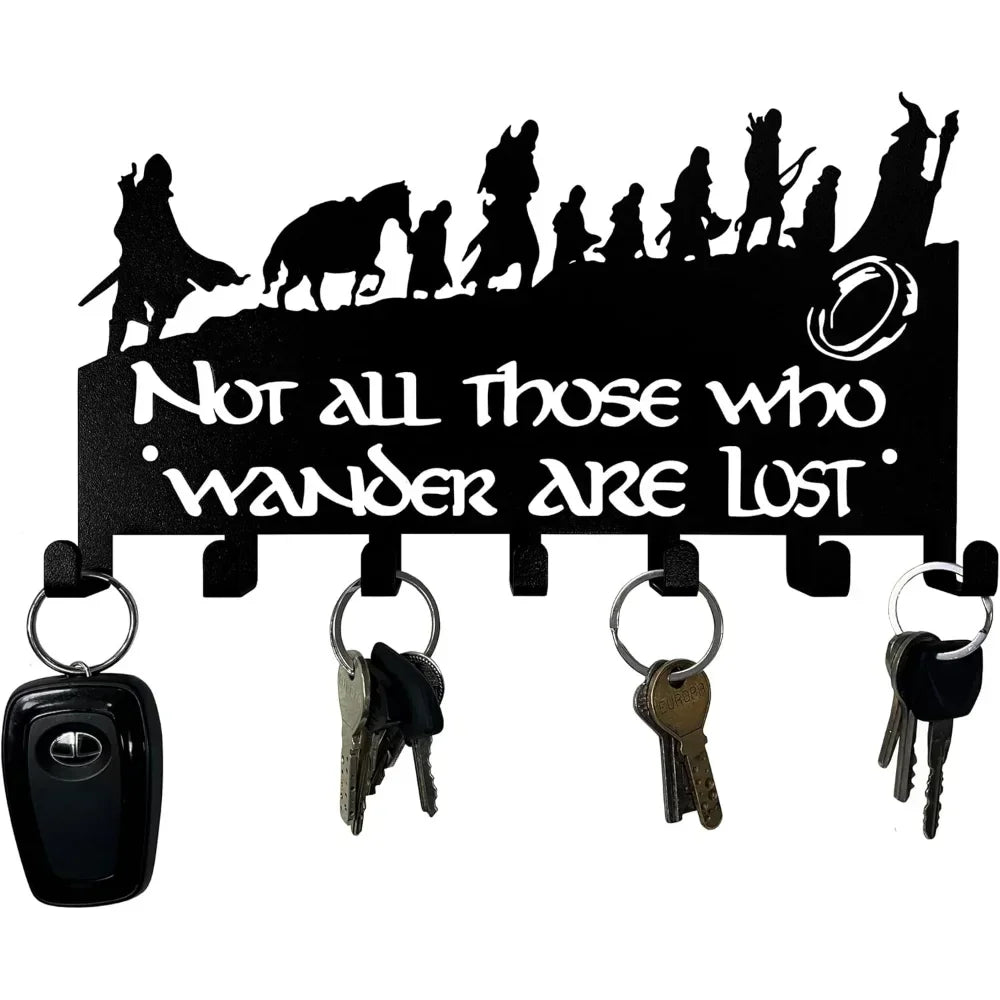 Decorative metal wall-mounted key holder with seven hooks displaying various keys.
