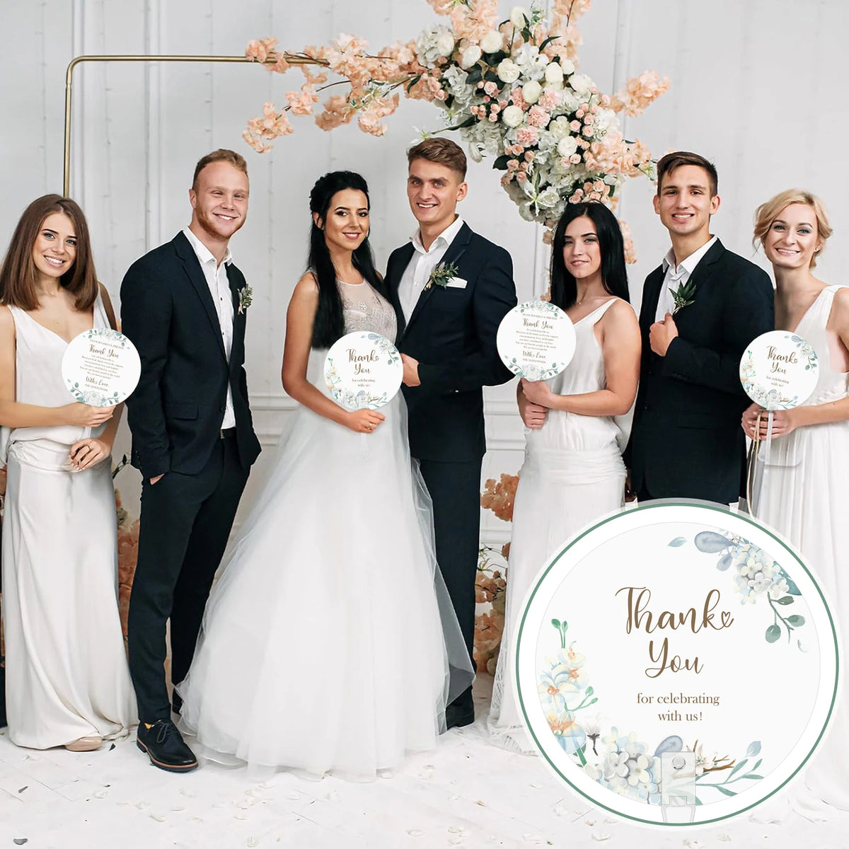 A group of ten people dressed in formal attire posing for a wedding photo surrounded by floral arrangements.