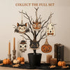 A set of vintage wooden Halloween hanging ornaments featuring a cat, skull, and owl, displayed on a dark surface.