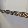A decorative bronze-colored acrylic mirror wall sticker featuring an intricate geometric pattern used as an edge or corner tr