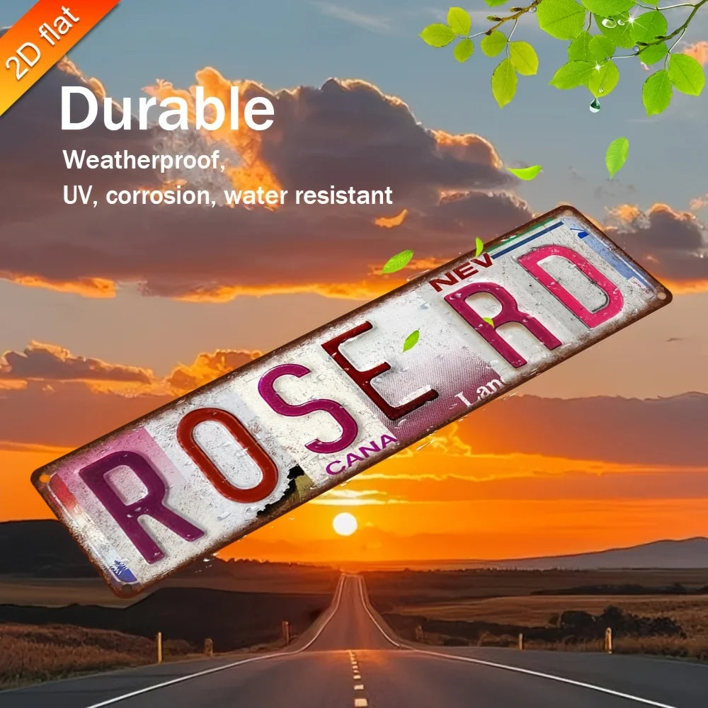 Vintage Retro Metallwandtafel in Form eines Wegeschilds mit der Aufschrift ROSE RD vor einer Sonnenuntergangslandschaft.