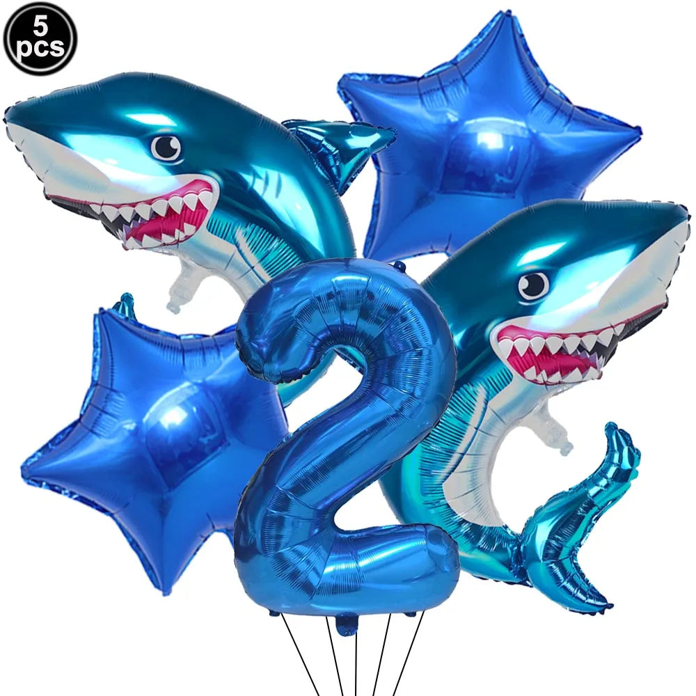 A set of five blue shark foil balloons, including a number two balloon, for an ocean-themed party decoration.