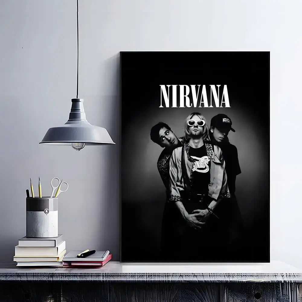A black poster featuring three figures in a grunge style, inspired by the Nirvana band, displayed on a shelf.