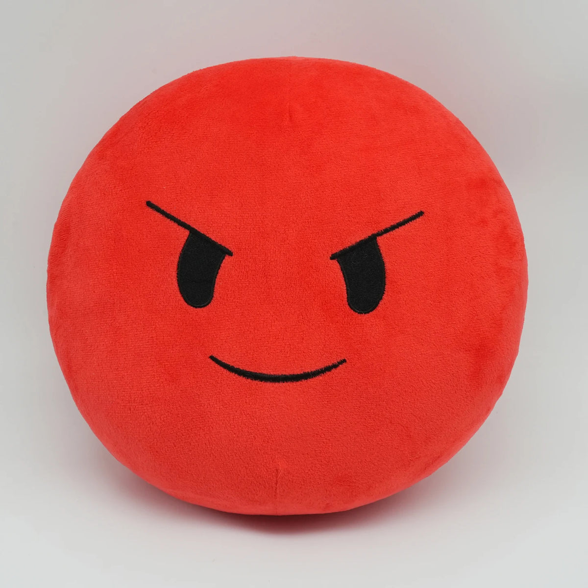 A round, bright red plush doll with a black, angry facial expression.