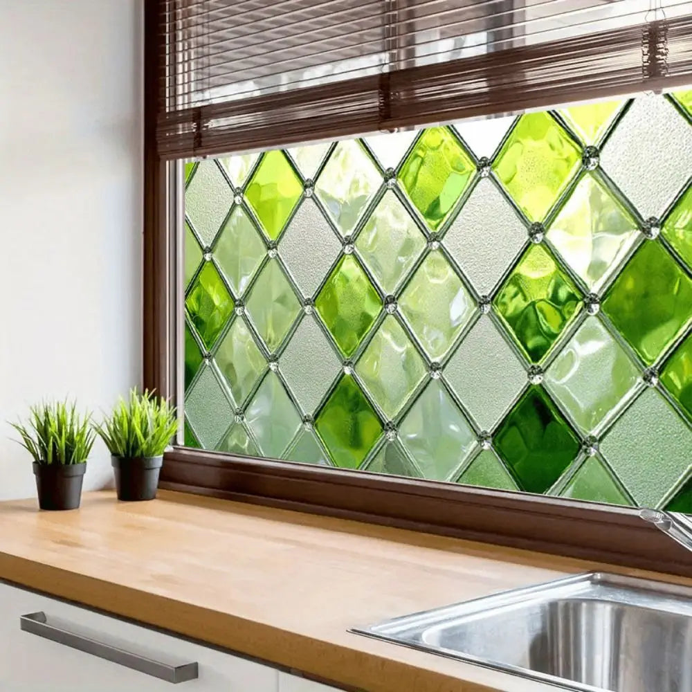 A close-up of a window featuring green leaf privacy film with a diamond pattern.
