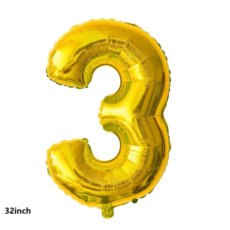 A shiny gold foil balloon shaped like the number three