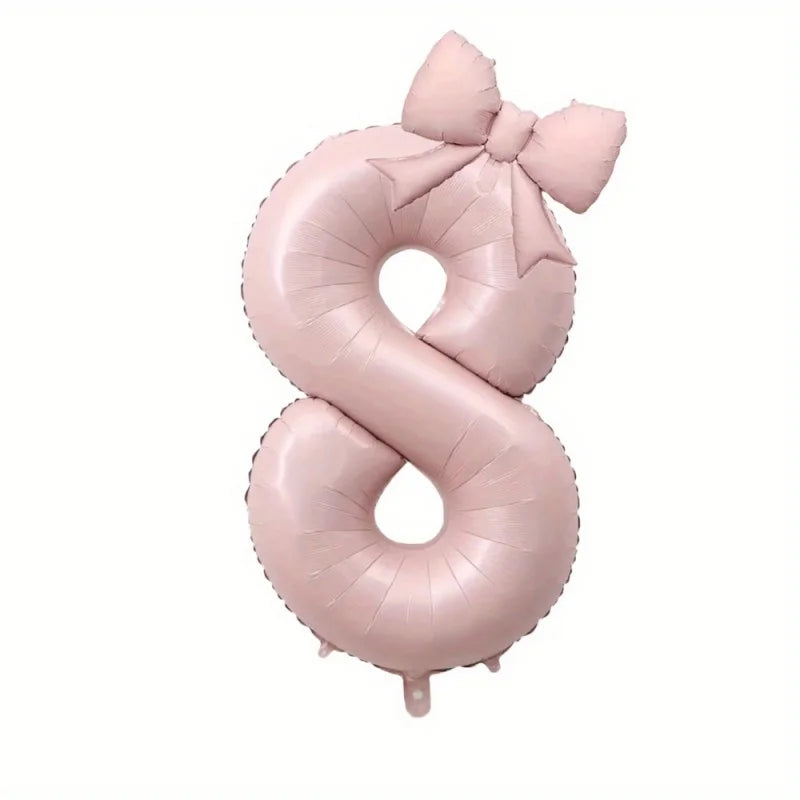 Large pink foil number balloon shaped like the number 8 with a bow