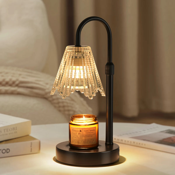 A black lamp with a textured glass shade and candle holder sits on a wooden surface.