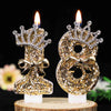 Gold glitter number cake topper candles featuring a rhinestone bow on a wooden base.