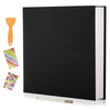 A black linen scrapbook photo album with a visible spine and an orange wooden tool lying next to it.