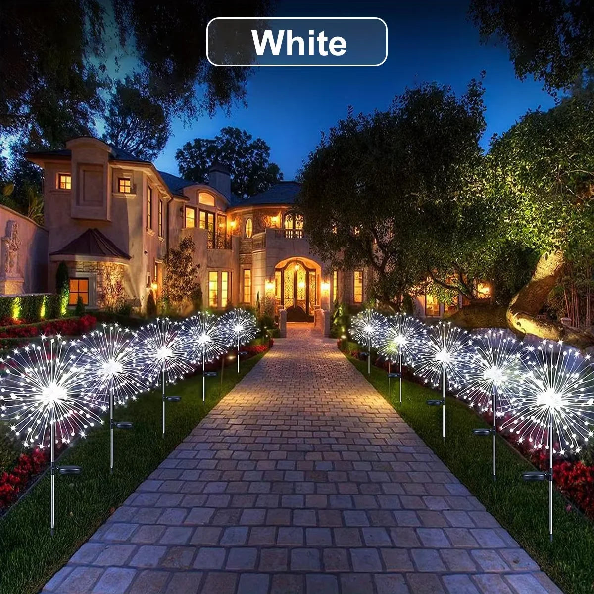 White solar fireworks garden lights illuminating a stone pathway and house at dusk.