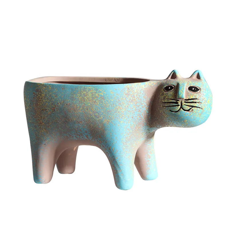 A ceramic succulent planter shaped like a cat with blue-green glaze and black whiskers.