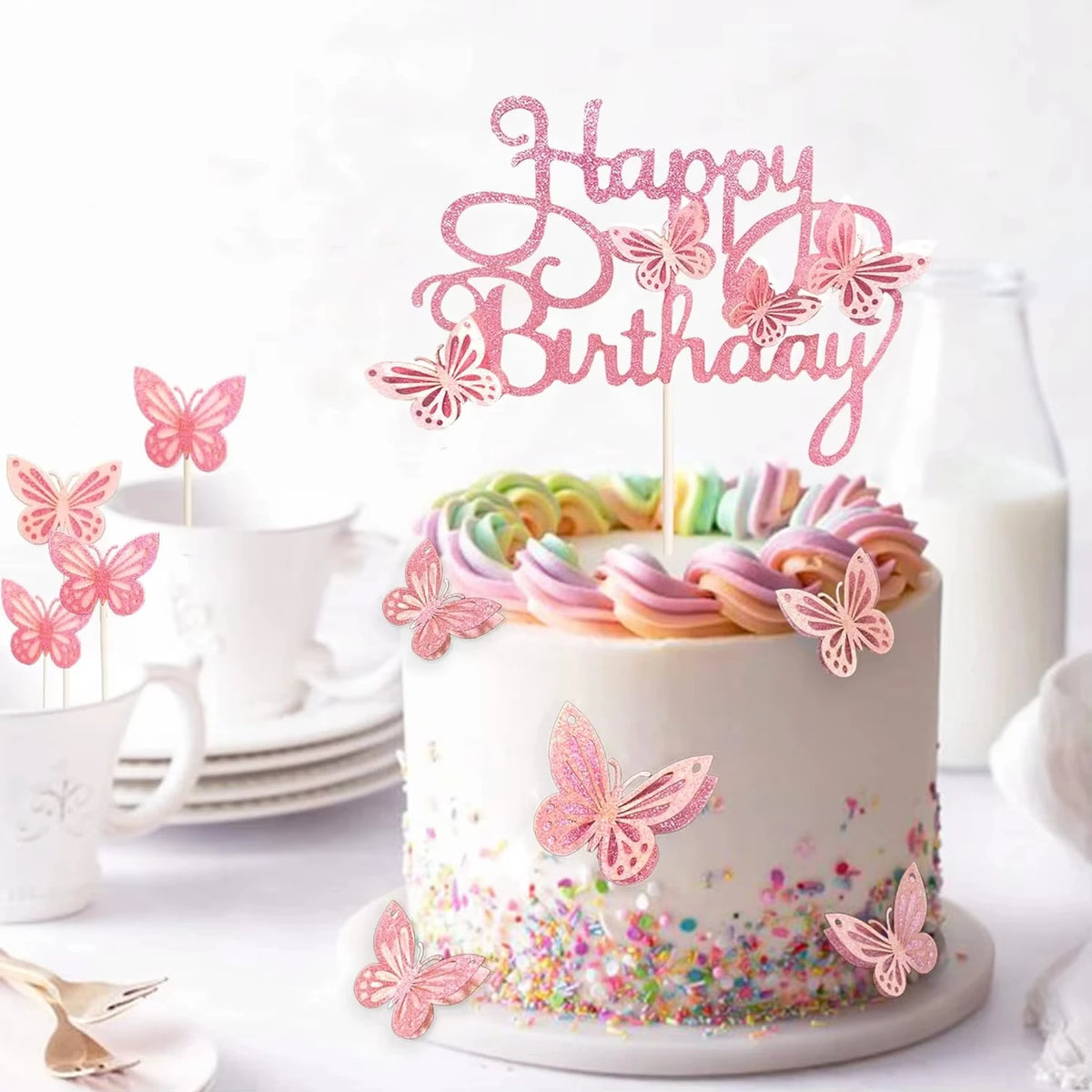 A white cake decorated with pink butterfly toppers and colorful frosting, set against a bright background.