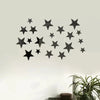 Black acrylic star mirror wall stickers arranged in a scattered pattern on a white wall.