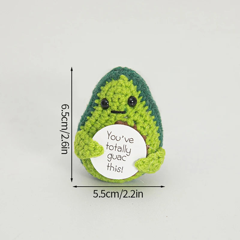 Handmade crochet potato doll with a green textured body and a white circular tag that reads You've totally guac this!